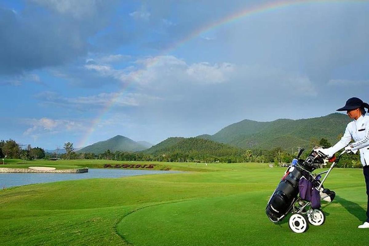 un home amb un carret de golf en un camp de golf