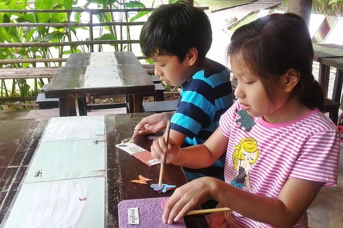 um casal de crianças brincando com papel em uma mesa