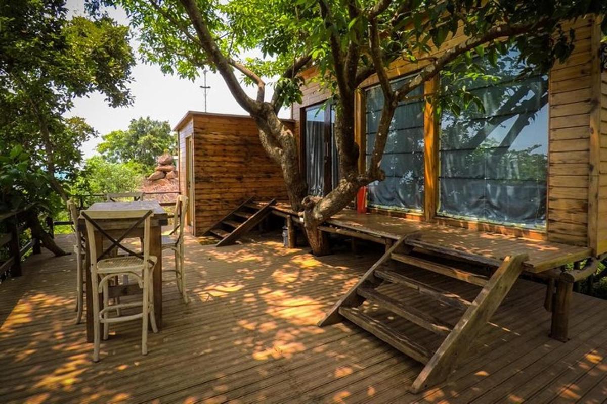 a wooden deck with a bench and a tree