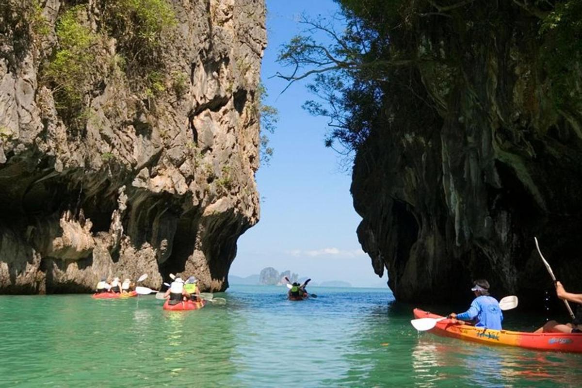 một nhóm người chèo thuyền kayak trên mặt nước gần một hang động