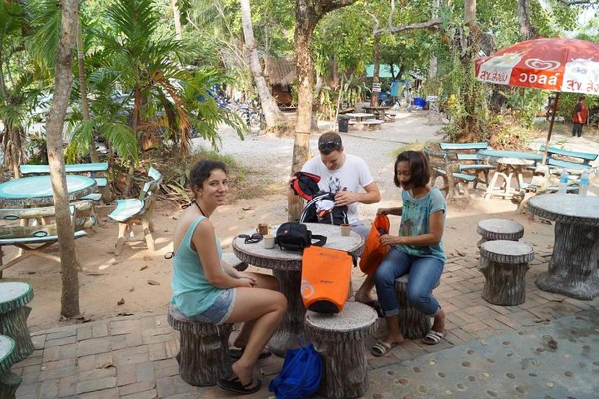 một nhóm người đang ngồi ở bàn ăn ngoài trời