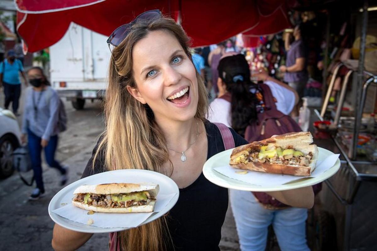 a woman holding two plates with sandwiches on them