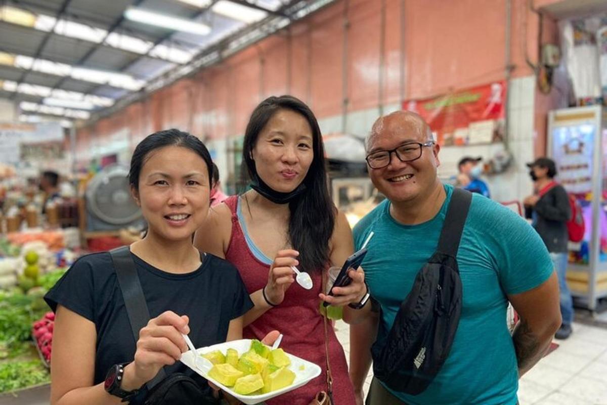 um grupo de três pessoas posando para uma foto em um supermercado