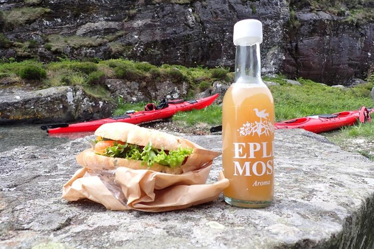 eine Flasche Bier und ein Sandwich auf einem Felsen