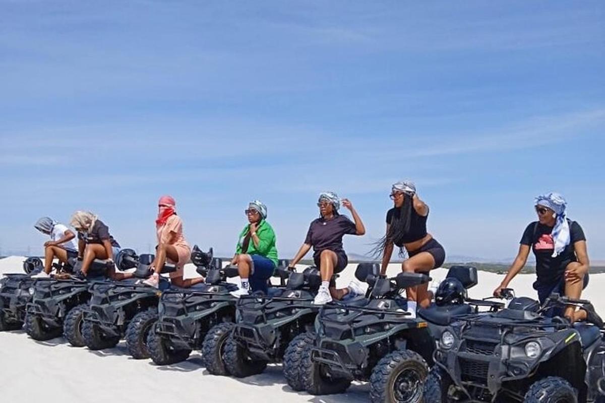 un grup de oameni stând pe ATV-uri pe plajă
