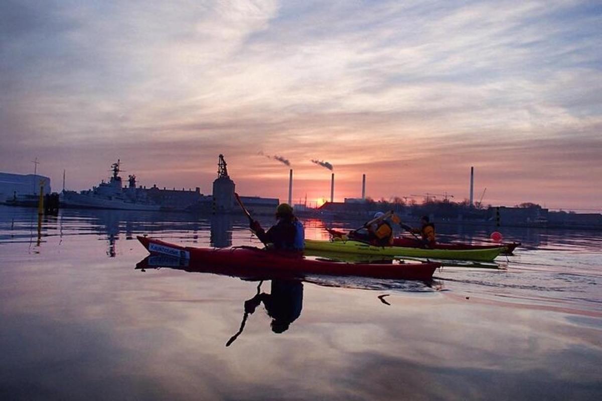 a group of people in kayaks on the water at sunset