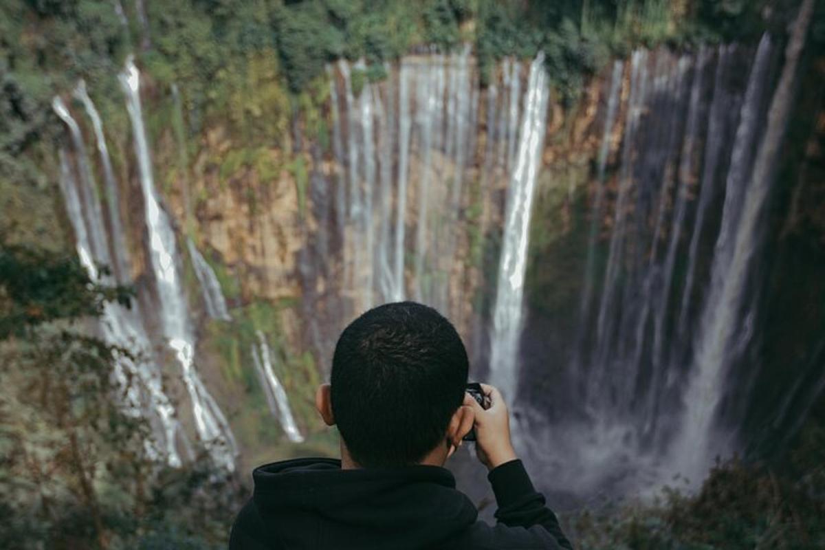 un uomo che scatta una foto di una cascata