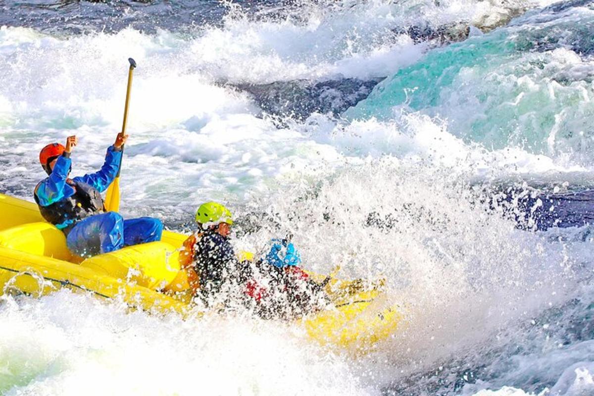 two people on a raft in the rapids of a river