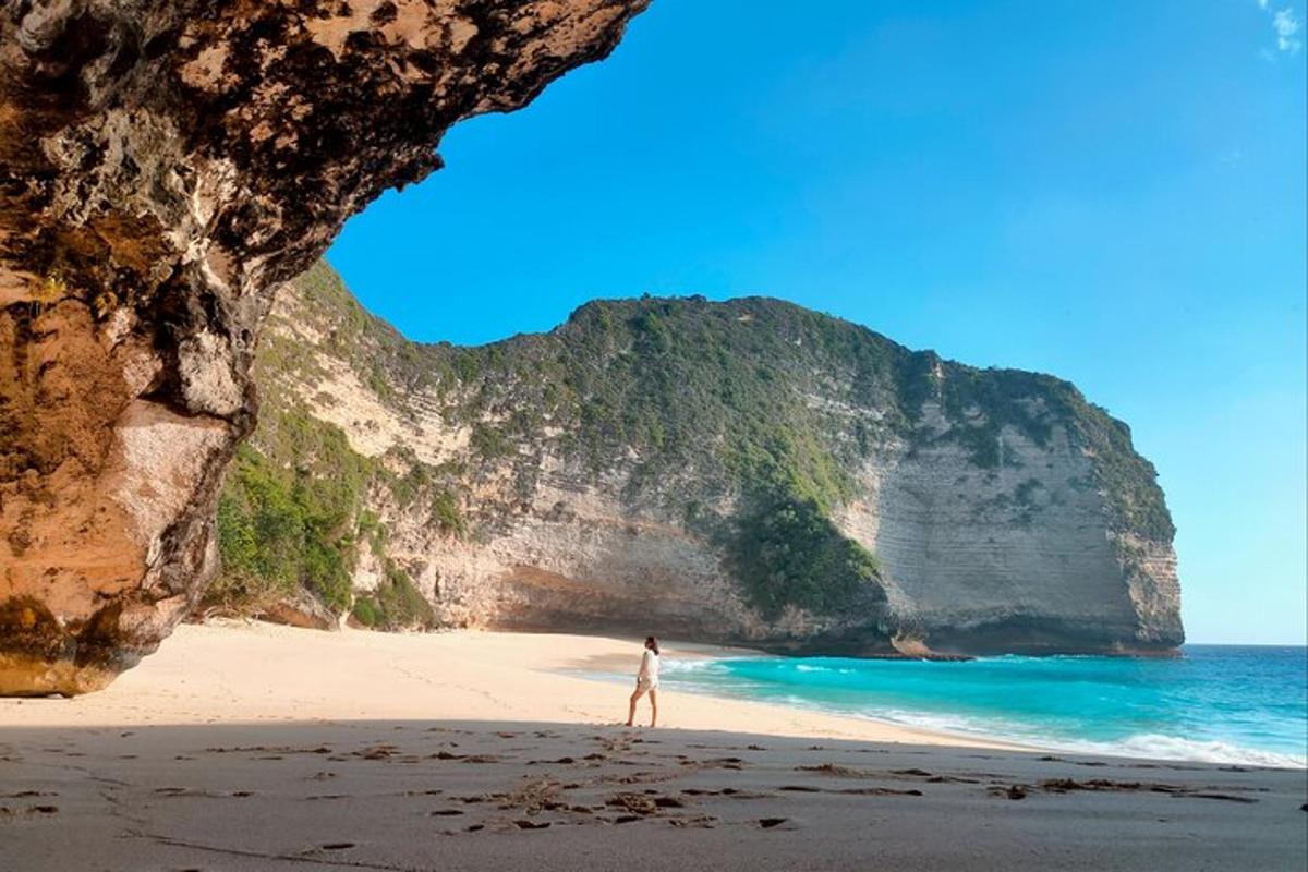 eine Person, die an einem Strand vor einer Höhle steht
