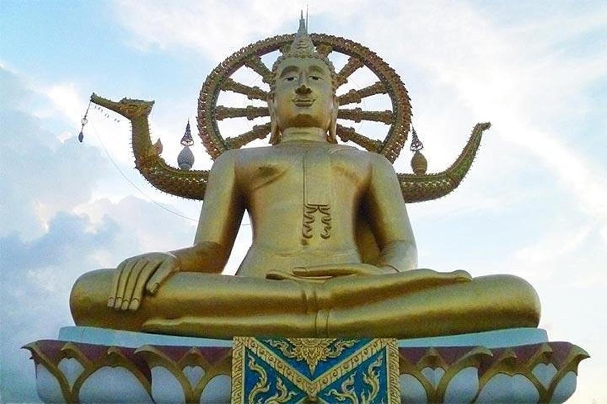 一座巨大的金色雕像，背景是船舵