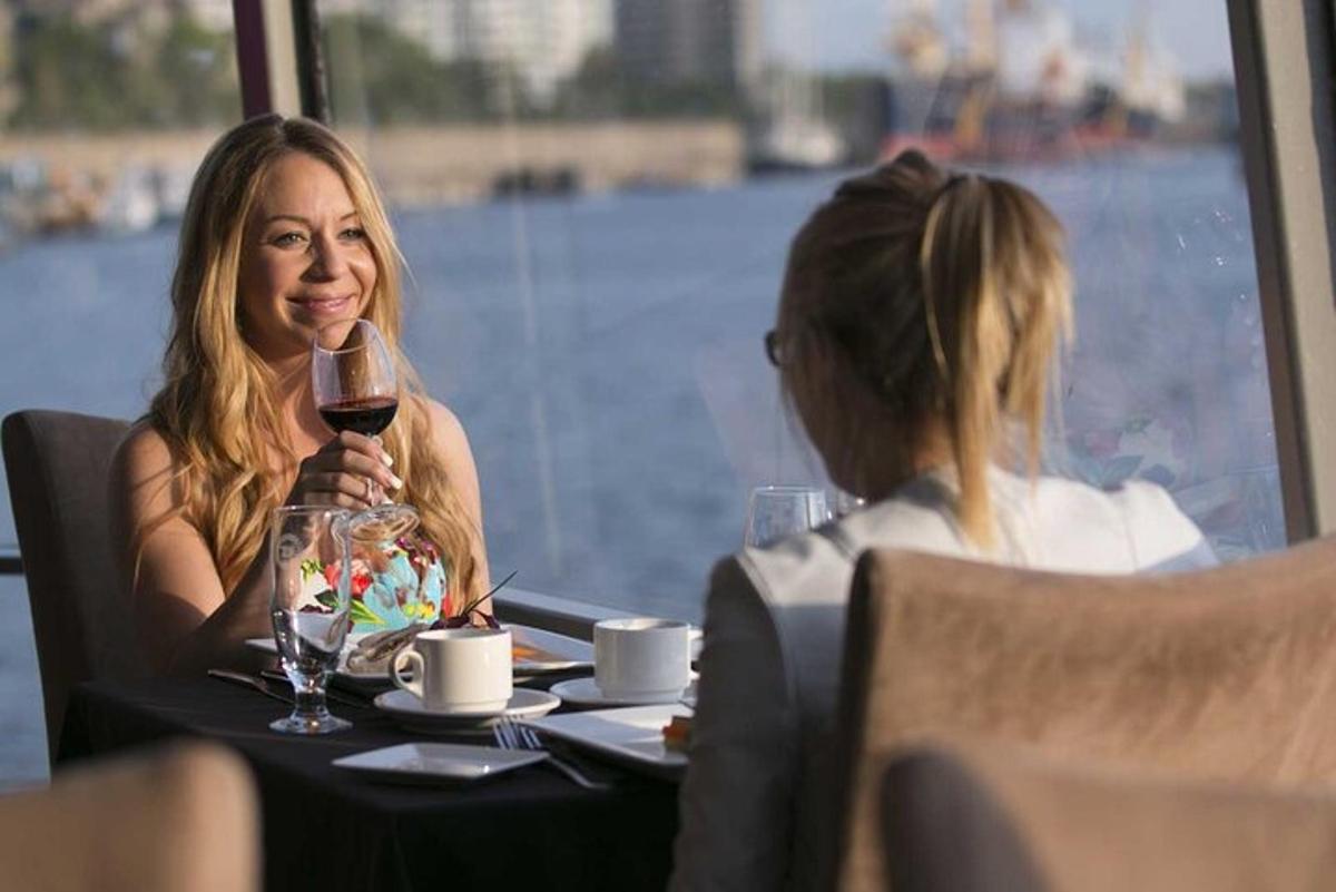 a woman sitting at a table with a glass of wine