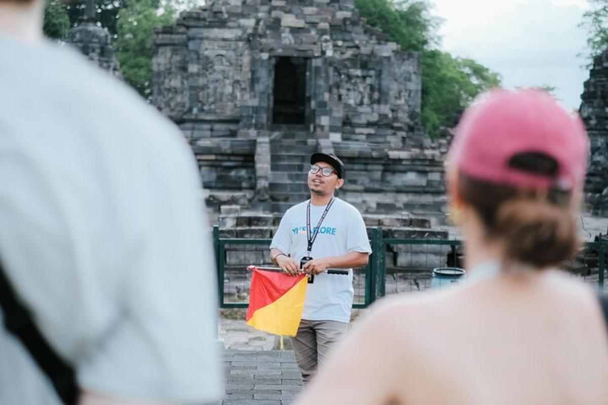 seorang lelaki memegang bendera di hadapan sebuah bangunan
