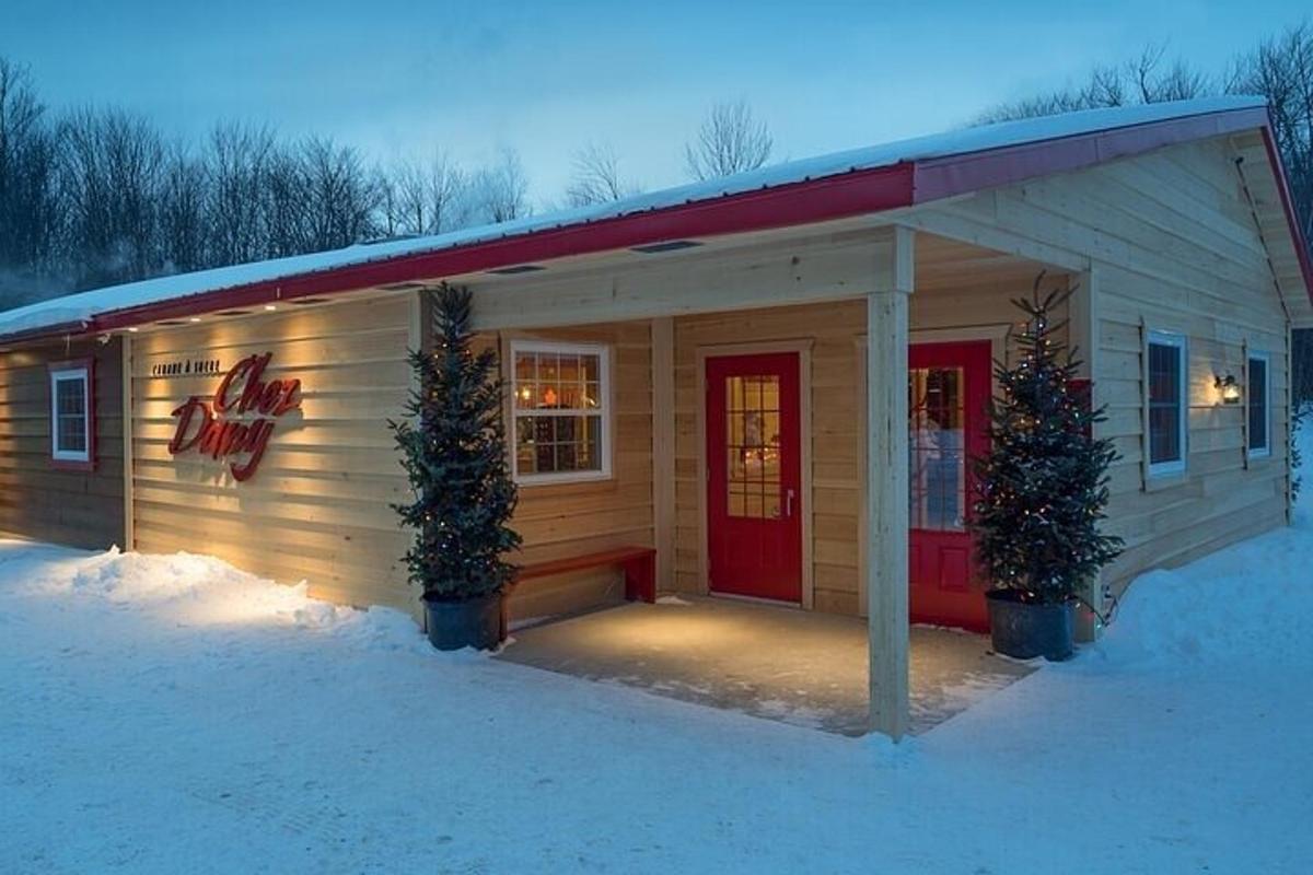 Una pequeña cabaña con una puerta roja en la nieve.