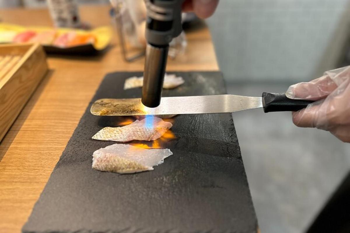 a person cooking food on a grill with a knife