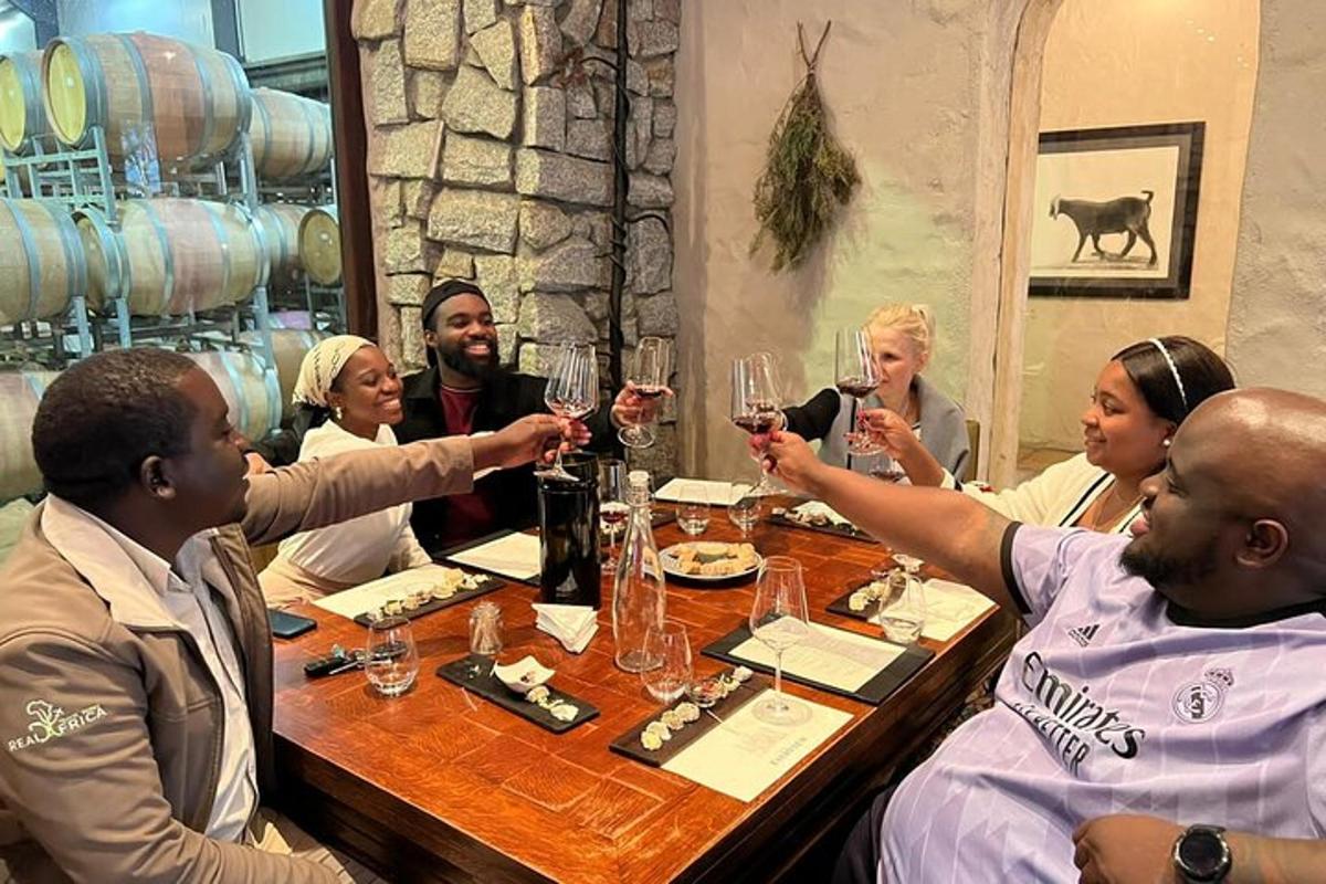 eine Gruppe von Menschen sitzt um einen Tisch und trinkt Wein