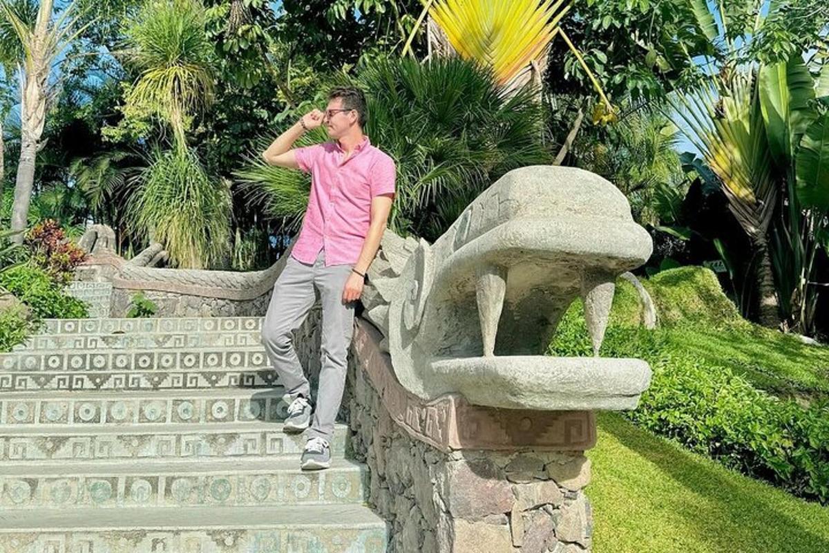 seorang lelaki berdiri di atas patung batu