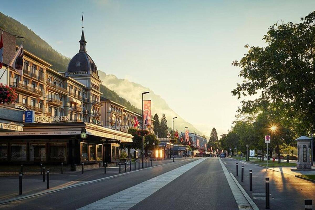 an empty city street with buildings and a mountain