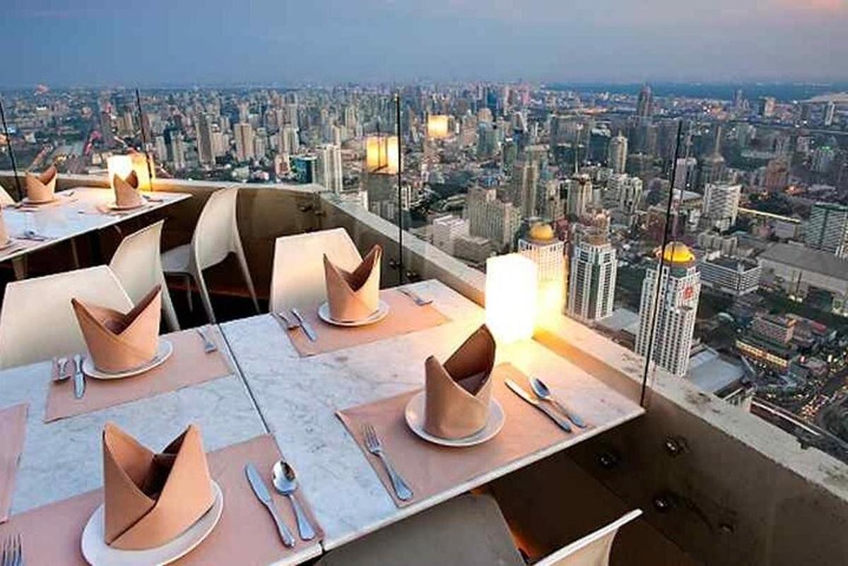 un ristorante con tavoli con cappelli in cima a una città