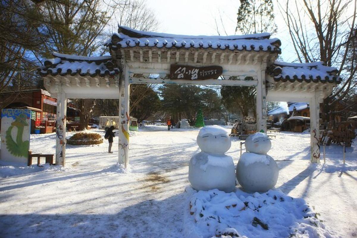 two snowmen sitting in front of a gazebo