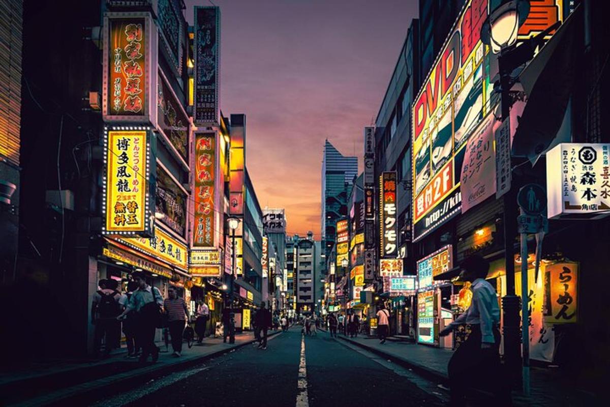 a city street at night with people walking down the street