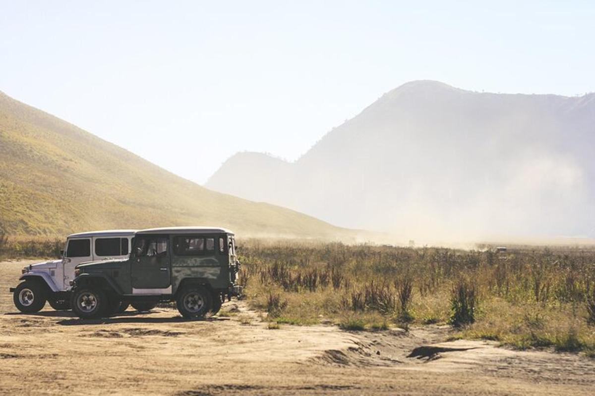 Un jeep estacionado en un camino de tierra en las montañas.