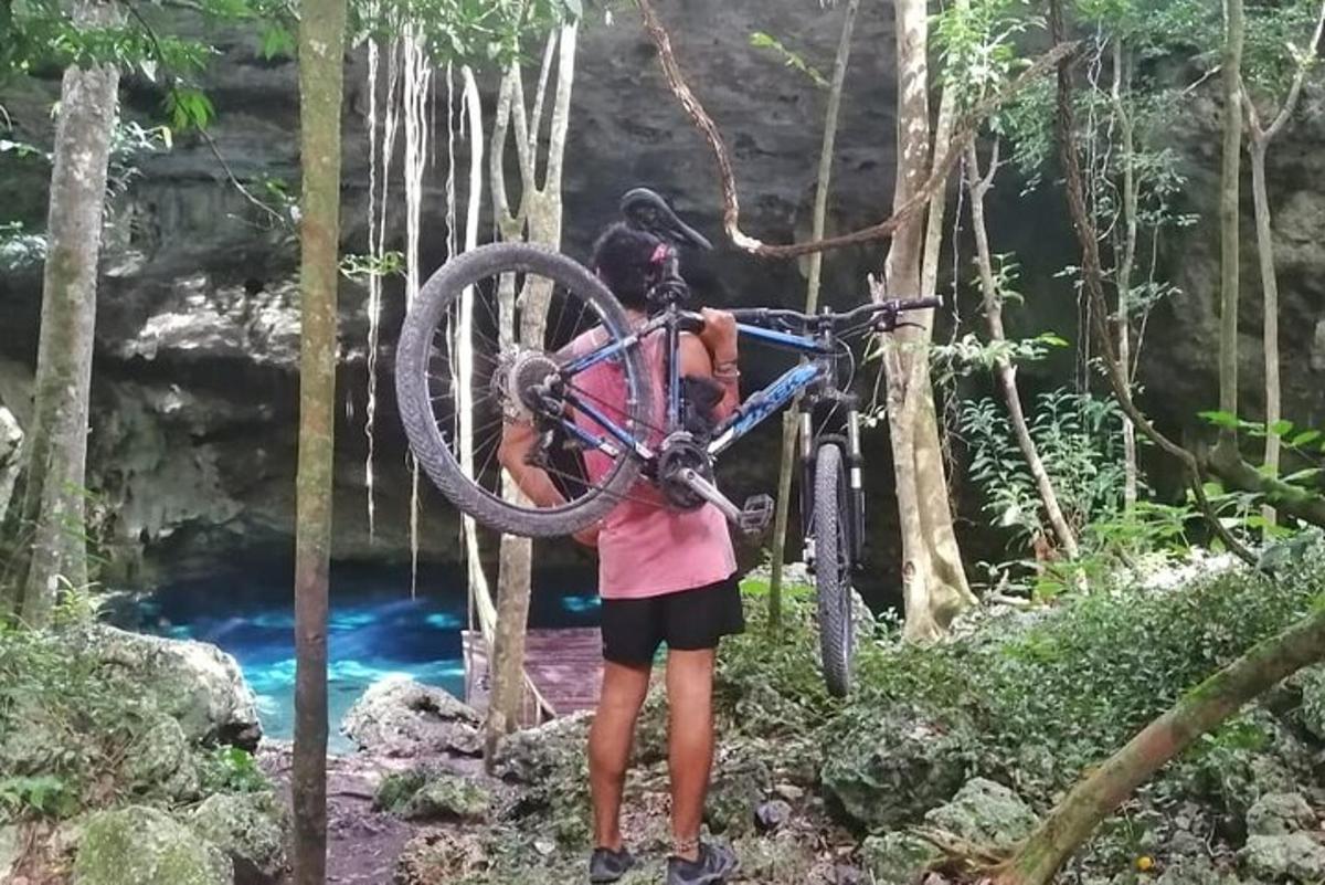 滝の前で自転車を抱えた女性