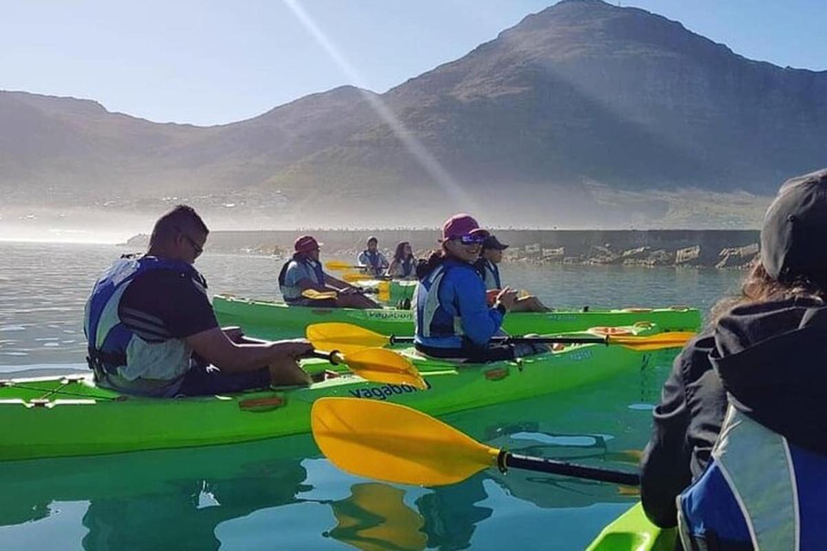 a group of people sitting in kayaks in the water