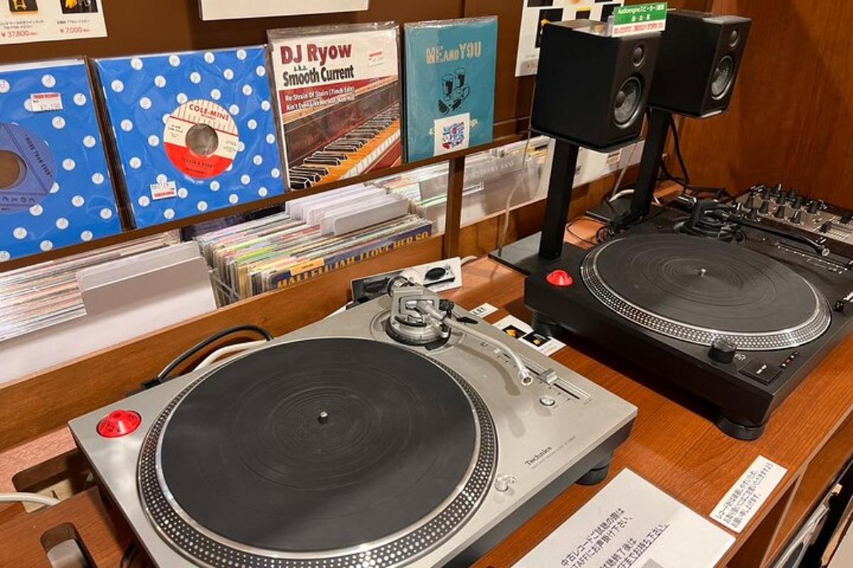 uma mesa com um mixer de discos e um toca-discos
