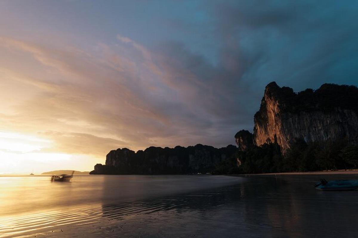 un tramonto su una spiaggia con una formazione rocciosa