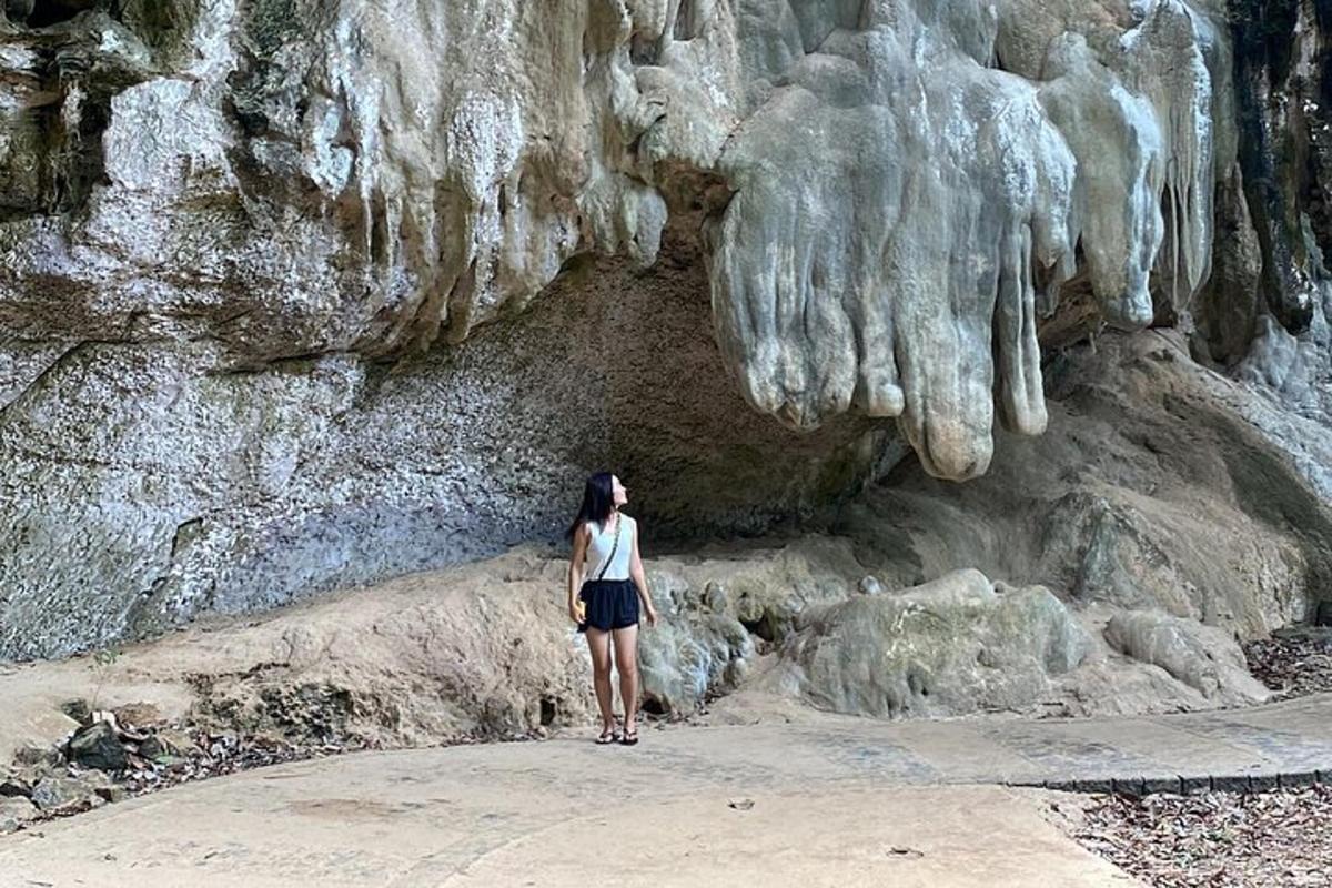 una donna in piedi davanti a una formazione rocciosa