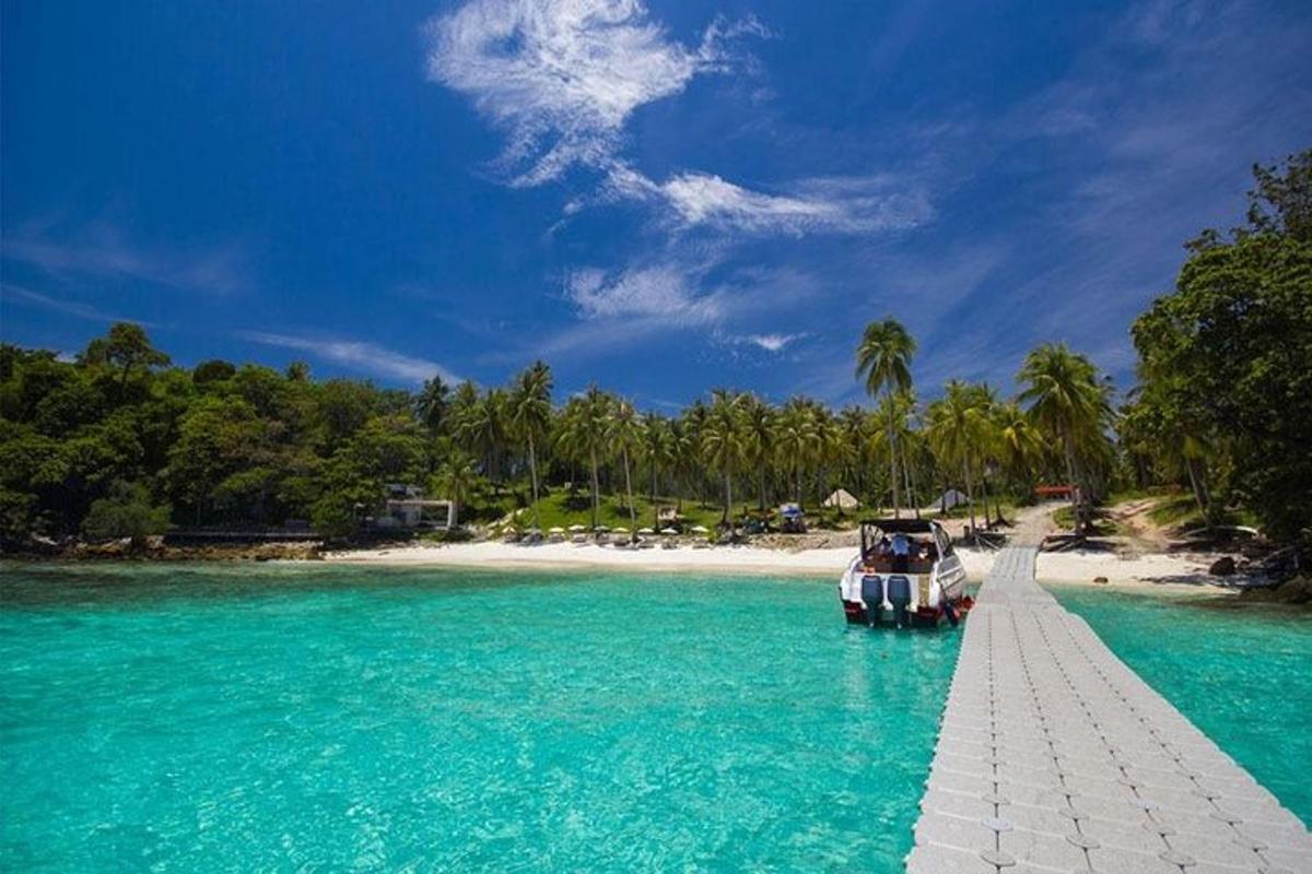 ein Boot auf einem Dock im Wasser neben einem Strand