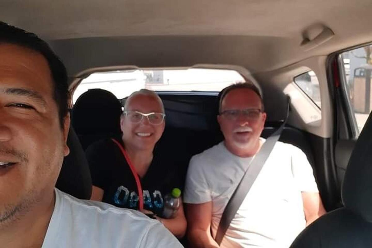 three people sitting in the back of a car