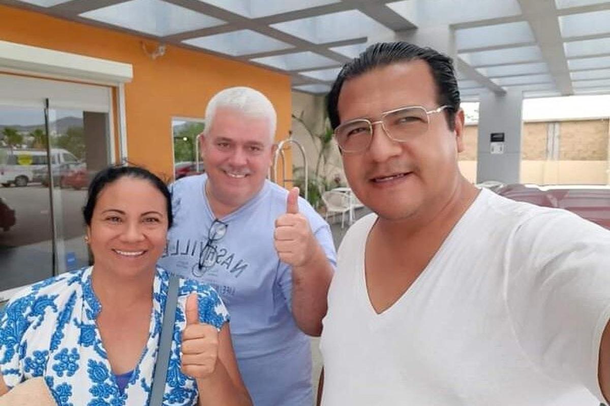two men and a woman giving a thumbs up