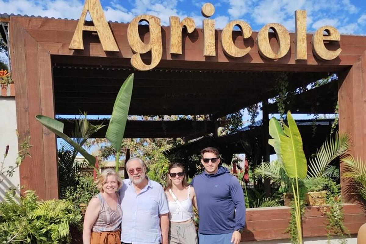 a group of people standing in front of a carotle sign