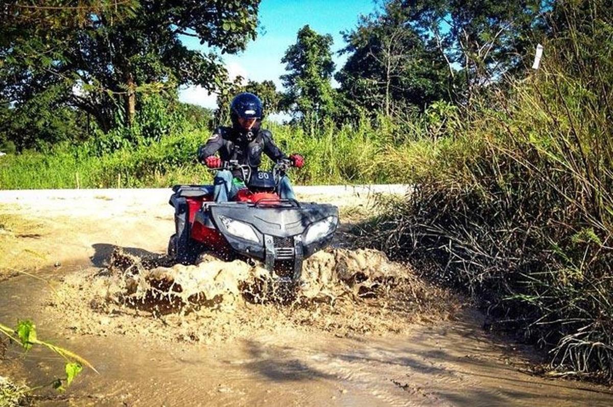 eine Person, die mit einem Quad über eine unbefestigte Straße fährt