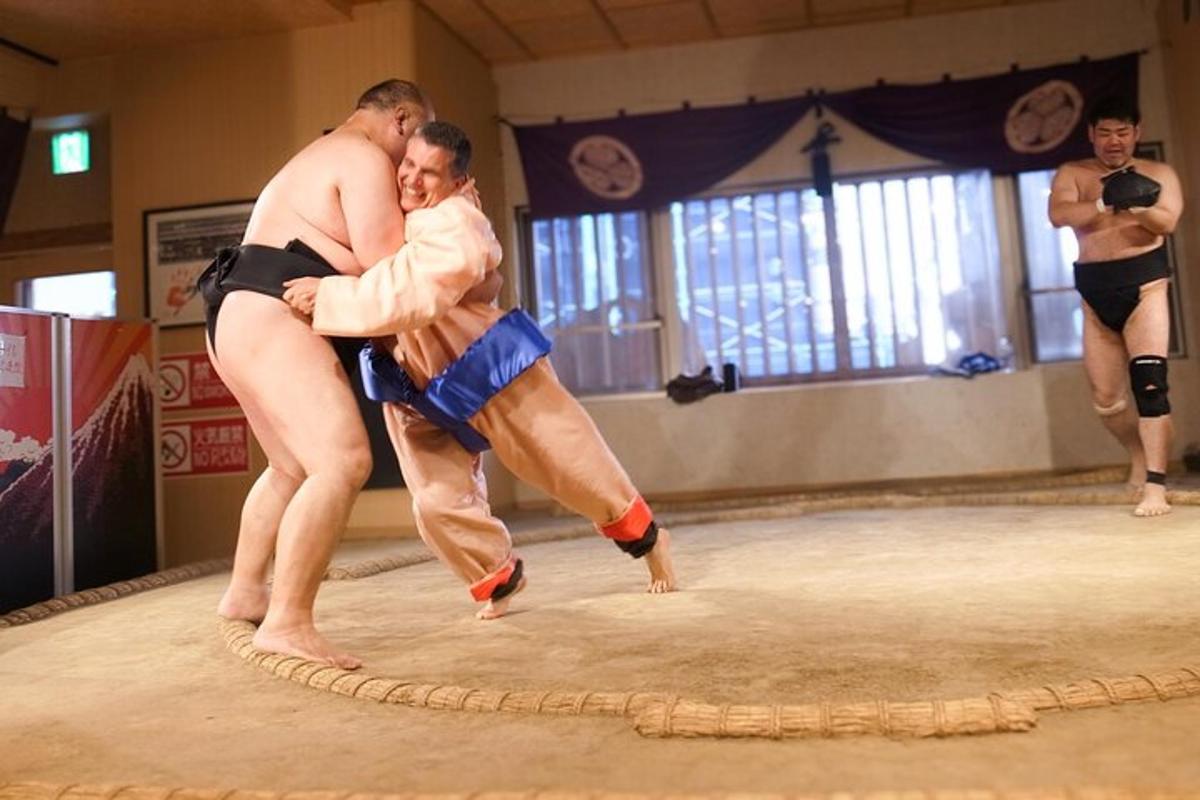 due lottatori di sumo che si abbracciano sul ring
