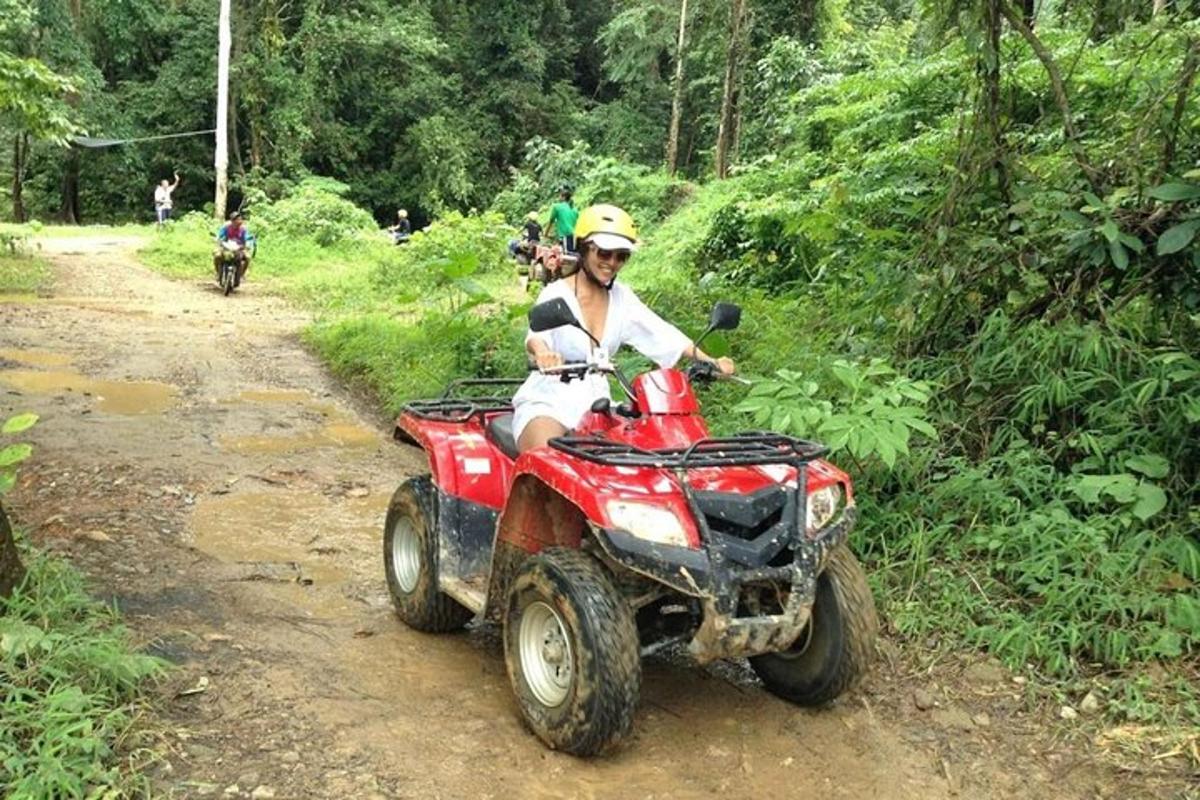 a man riding a four wheeler on a dirt road