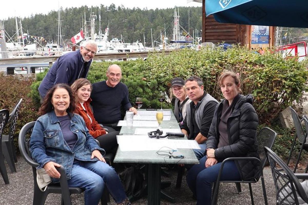 un gruppo di persone sedute a un tavolo di fronte a un porto turistico