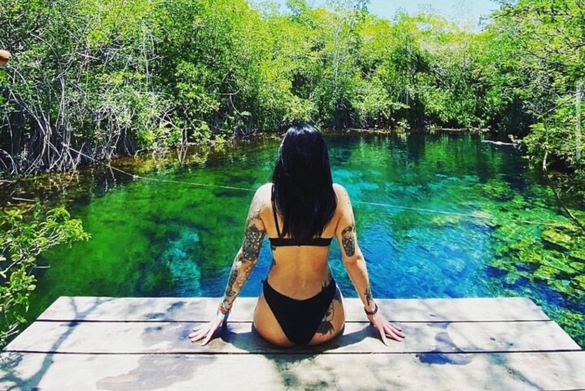 una donna in bikini seduta su un molo in acqua