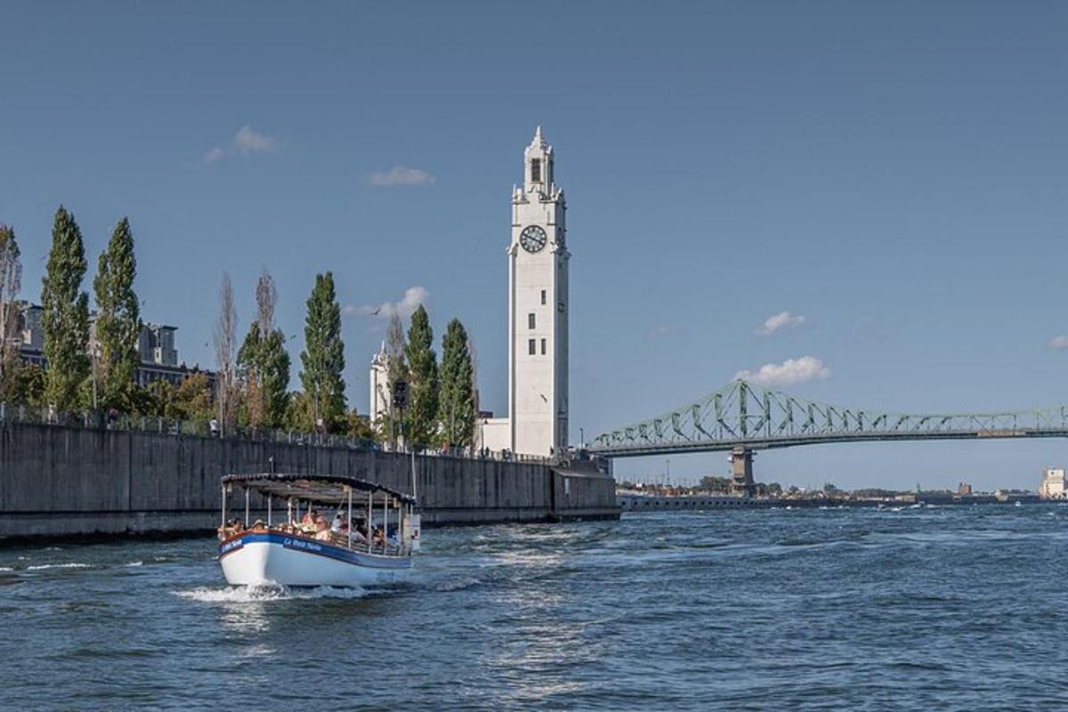 a boat in the water with a clock tower and a bridge