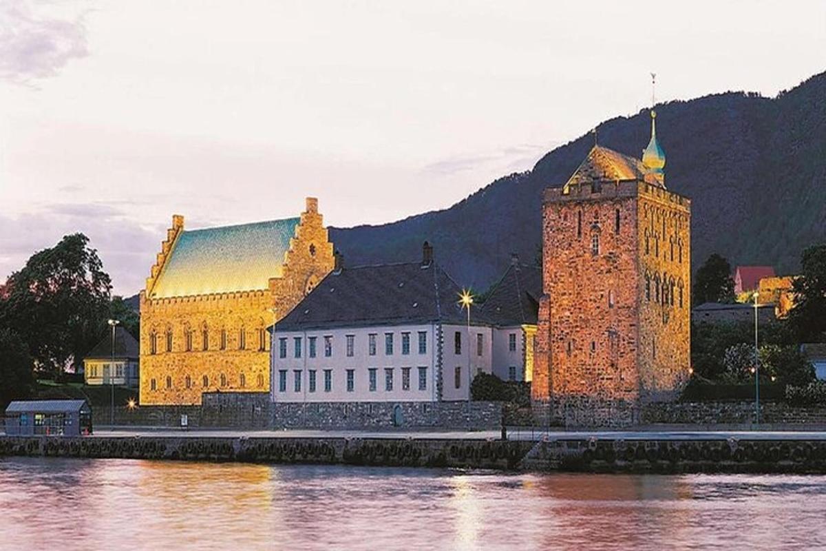 a large building with a clock tower next to the water