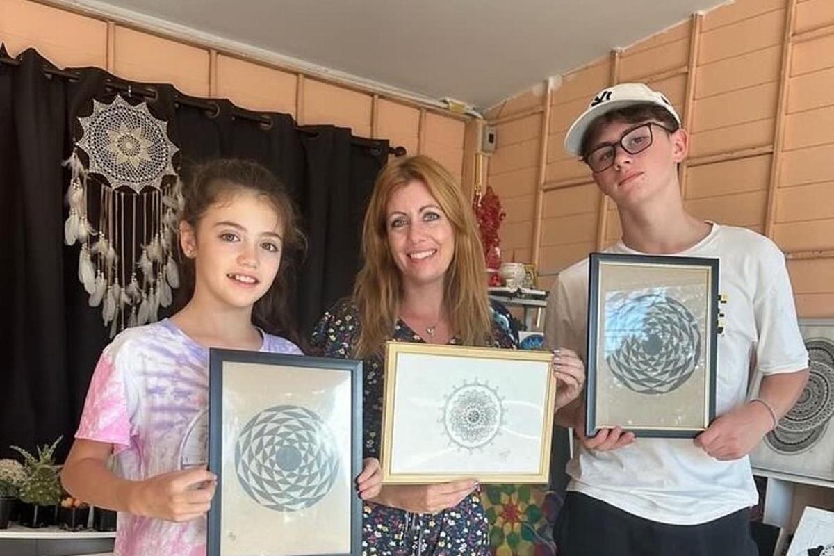 žena a dvě děti držící zarámované certifikáty