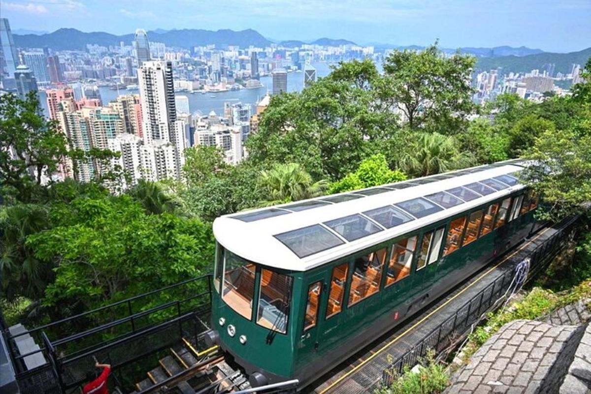 um trem verde nos trilhos perto de uma cidade