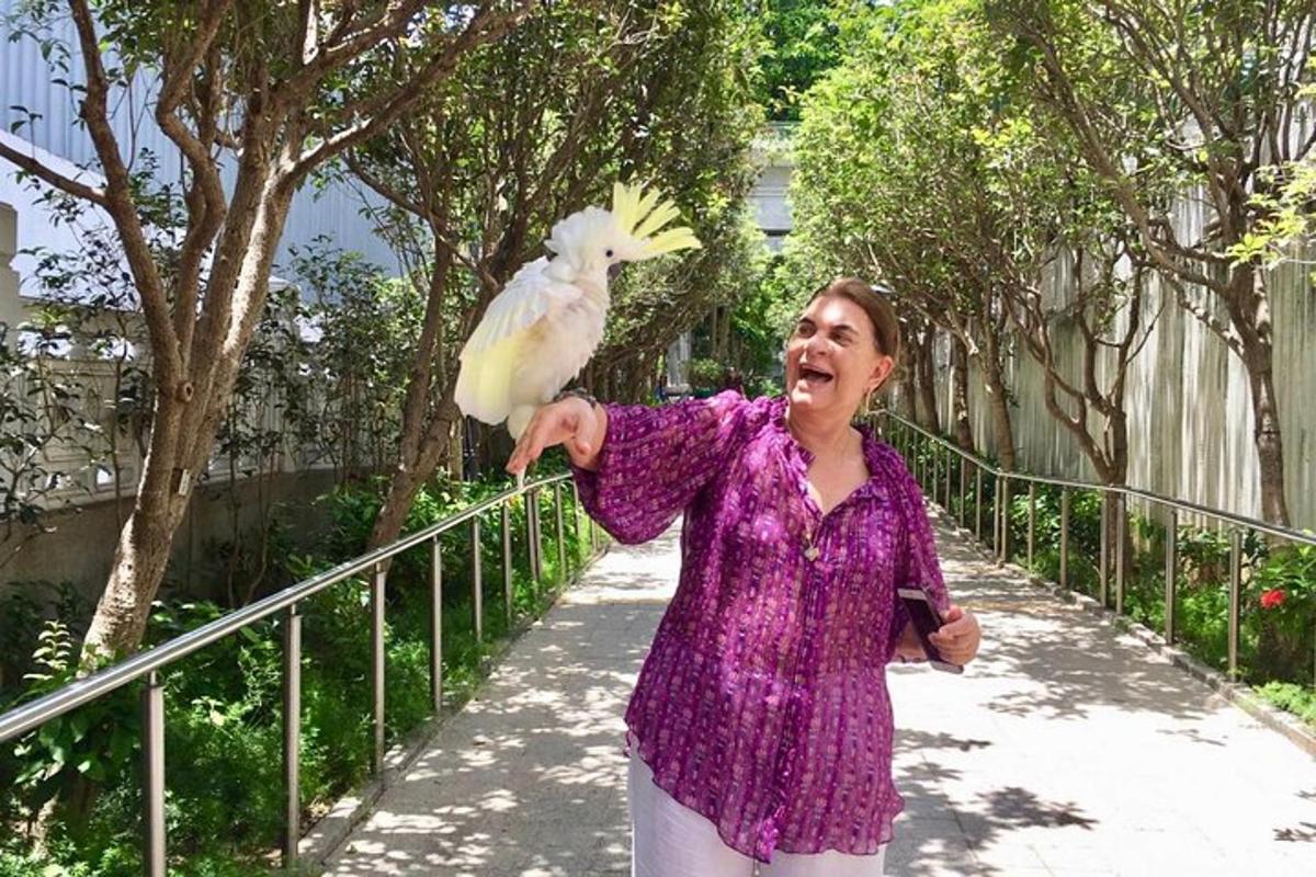 a woman is holding a bird on her arm