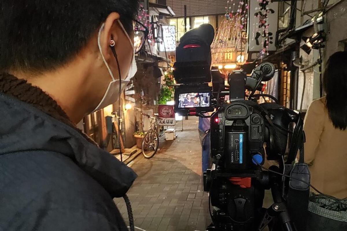 a man standing next to a camera on a street