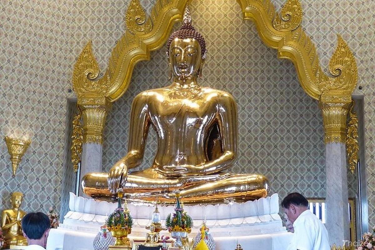 uma grande estátua dourada de um buda em uma sala