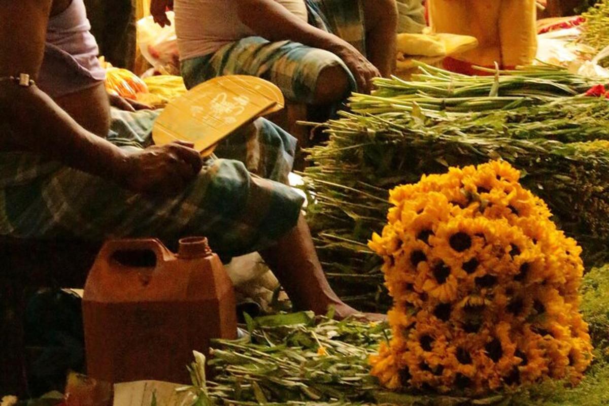 o persoană așezată lângă o grămadă de legume