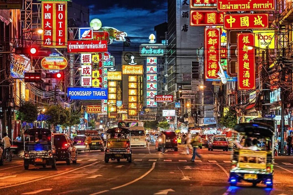 uma rua movimentada da cidade à noite com carros e placas