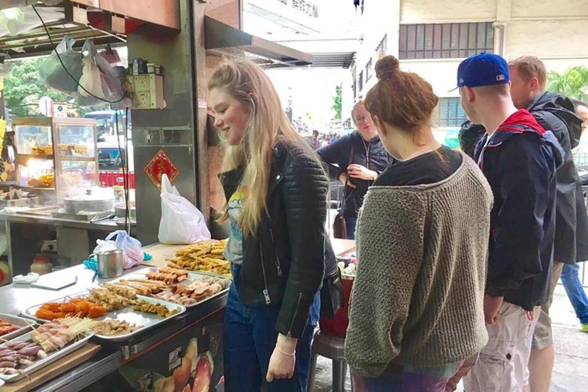 skupina lidí stojících kolem bufetu s jídlem