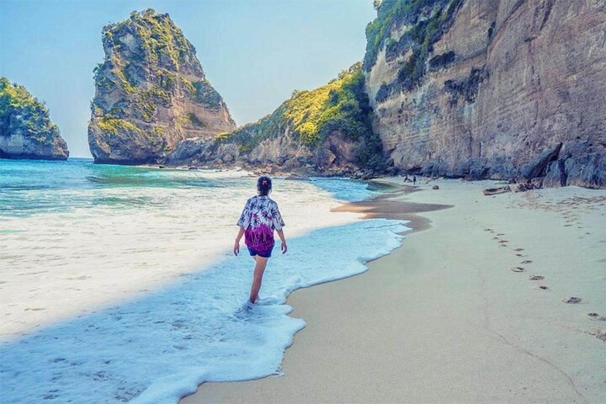 ženska, ki hodi po plaži blizu oceana